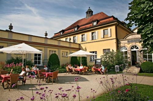 eine Gruppe von Personen, die vor einem Gebäude an Tischen sitzen in der Unterkunft Badhotel Bad Brückenau in Staatsbad Brückenau