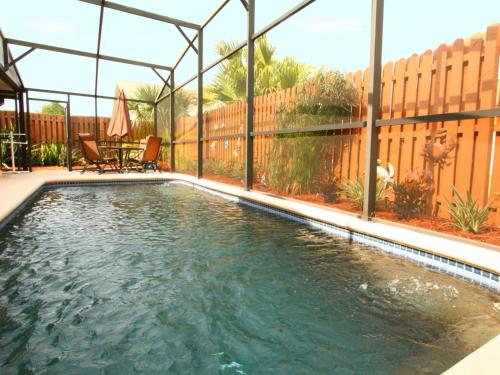 a swimming pool in a backyard with a fence at 2 Bed 5325 in Kissimmee