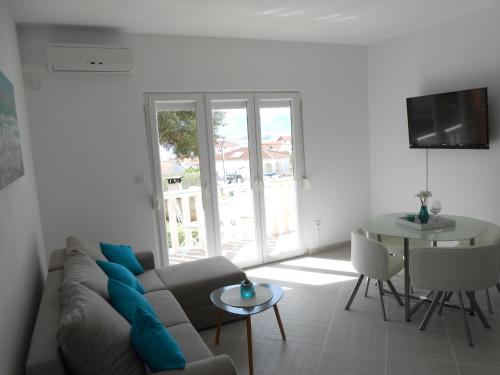 ein Wohnzimmer mit einem Sofa und einem Tisch in der Unterkunft Apartment Okrug Gornji 13859a in Trogir