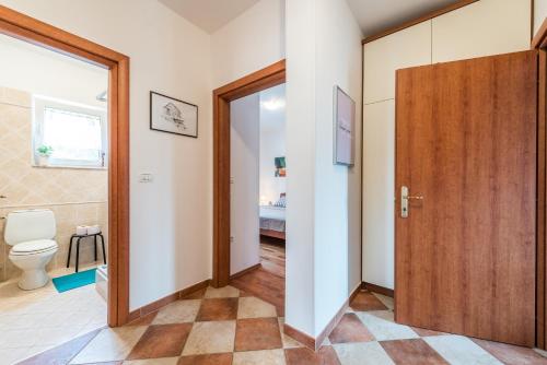 ein Badezimmer mit einem WC und einer Holztür in der Unterkunft Family friendly apartments with a swimming pool Sutomiscica, Ugljan - 13872 in Preko