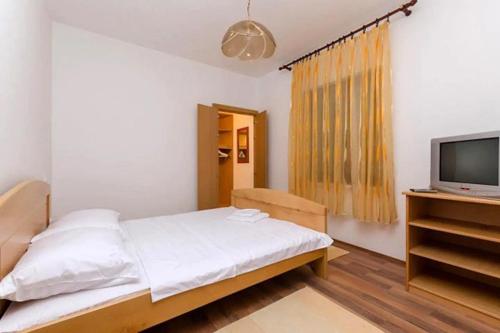 a bedroom with a bed and a flat screen tv at Family friendly house with a parking space Tribalj, Crikvenica - 13877 in Tribalj