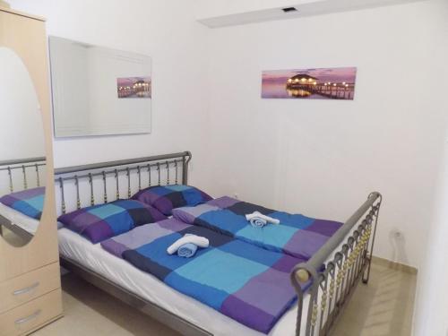 a bedroom with a bed with a blue and purple comforter at Apartments with a parking space Matulji, Opatija - 13890 in Matulji
