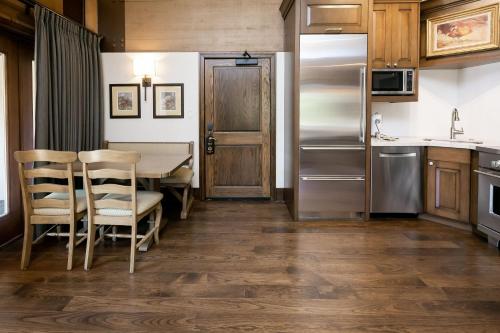 a kitchen with a table and chairs and a refrigerator at Sterling Studio Hotel Room in Park City
