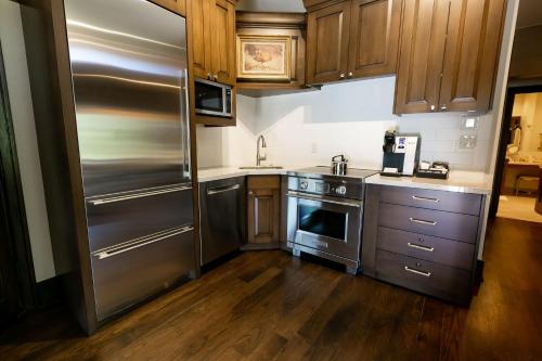 uma cozinha com utensílios de aço inoxidável e armários de madeira em Sterling Studio Hotel Room em Park City