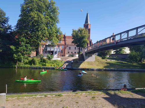 a group of people in canoes in the water under a bridge at DRAGO Helles 3 Raum Appartement auf der Dominsel im Herzen der Stadt in Brandenburg an der Havel