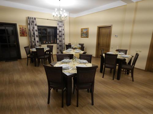 a dining room with tables and chairs and a chandelier at Pensiunea Vis Alpin Belis in Beliş