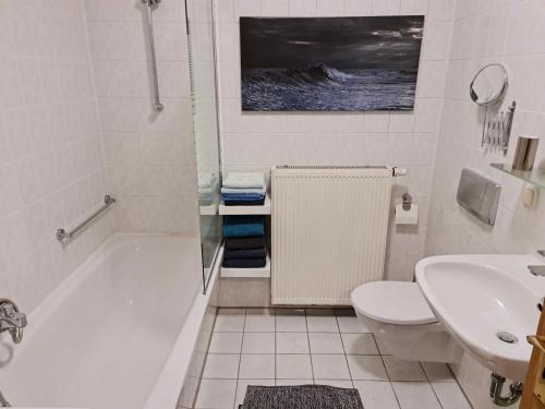 a bathroom with a tub and a toilet and a sink at KARINO helles Apartment über den Havel-Gärten auf der Dominsel in Brandenburg an der Havel