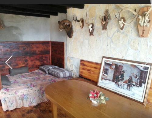 ein Schlafzimmer mit einem Bett und einem Tisch und Geweihen an der Wand in der Unterkunft Family friendly house with a swimming pool Zagvozd, Zagora - 13901 in Zagvozd