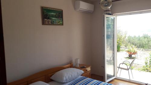 a bedroom with a bed and a sliding glass door at Apartments by the sea Kuciste - Perna, Peljesac - 13921 in Kučište