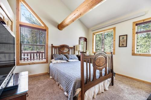 a bedroom with a bed and two windows at Boulder Ridge Lodge in Lead