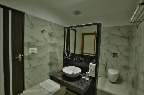 a bathroom with a sink and a mirror at Jhansi Hotel in Jhānsi