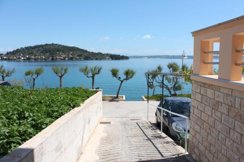 a car parked outside of a house with a view of a lake at Apartments by the sea Kali, Ugljan - 13865 in Kali