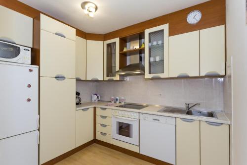une cuisine avec des armoires blanches et un évier dans l'établissement Apartments with WiFi Split - 13957, à Split