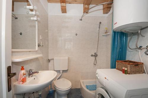 a small bathroom with a sink and a toilet at Seaside holiday house Maslinica, Solta - 13965 in Grohote