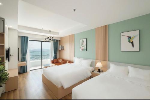 a hotel room with two beds and a window at TMS Pullman Quy Nhơn - Mộc's House in Quy Nhon