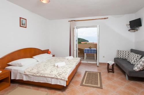 a bedroom with a bed and a couch at Apartments and rooms by the sea Lopud, Elafiti - 14013 in Lopud