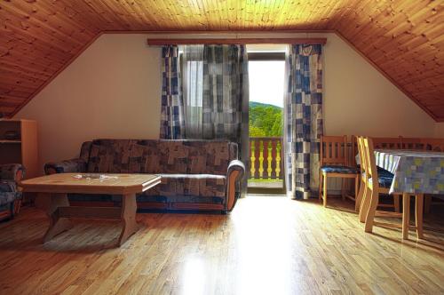 - un salon avec un canapé, une table et une fenêtre dans l'établissement Apartment Smoljanac 14023a, à Smoljanac