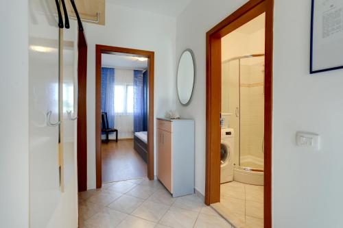 a bathroom with a toilet and a sink and a mirror at Family friendly apartments with a swimming pool Kastel Sucurac, Kastela - 14047 in Kaštela