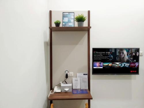 a mirror on a wall next to a table at Cottonwood Boutique Heritage Otten in Bandung