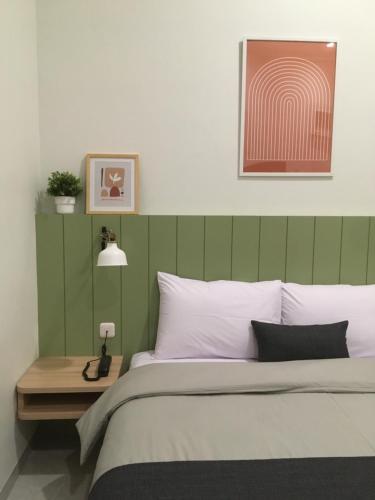 a bedroom with a bed with a green headboard at Cottonwood Boutique Heritage Otten in Bandung