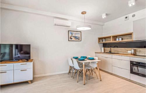 a kitchen with a table and chairs in a room at Amazing Apartment In Mrzezyno With Wifi in Mrzeżyno