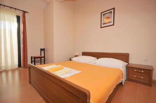 sypialnia z dużym pomarańczowym łóżkiem w pokoju w obiekcie Apartments with a parking space Okrug Donji, Ciovo - 13732 w mieście Okrug Donji