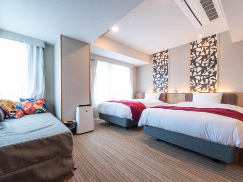 a hotel room with two beds and two windows at Hotel SUI Kyoto Kiyomizu in Kyoto