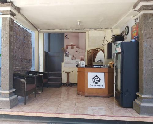 a room with a kitchen with a counter and a refrigerator at Genta House in Kuta