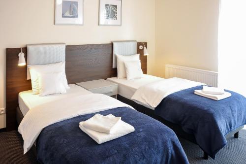 2 Betten in einem Hotelzimmer mit Handtüchern darauf in der Unterkunft Apartamenty Starówka - Riverside in Stettin