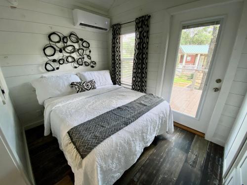 a bedroom with a bed and a large window at Farmhouse Style Tiny Home with Patio - 4 mi to Town in Fredericksburg