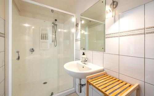 a white bathroom with a sink and a shower at Aqua Sands #2 in Oneroa
