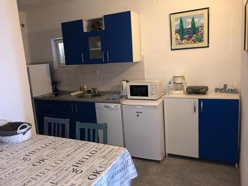 トゥチェピにあるApartments by the sea Tucepi, Makarska - 2699の小さなキッチン(青いキャビネット、電子レンジ付)