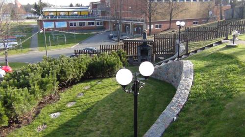 a park with a fence and street lights in the grass at Prie Galvės in Trakai