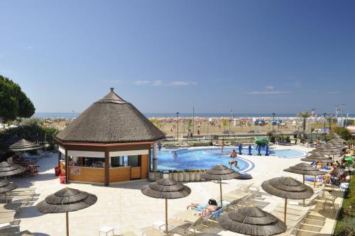 a resort with a pool with umbrellas and people swimming at Ashanti Aparthotel Wellness&Spa in Bibione