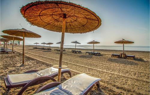 grupa leżaków i parasoli na plaży w obiekcie Awesome Apartment In Los Alcázares w mieście Los Alcázares