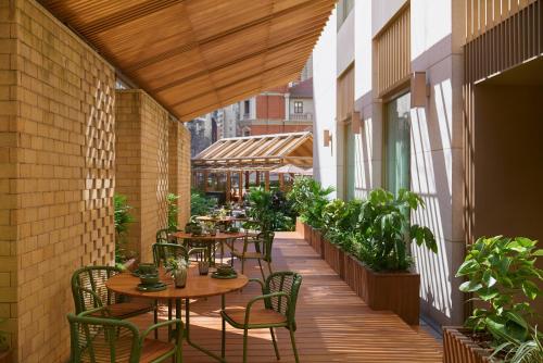 an outdoor patio with tables and chairs and plants at The Sukhothai Shanghai in Shanghai