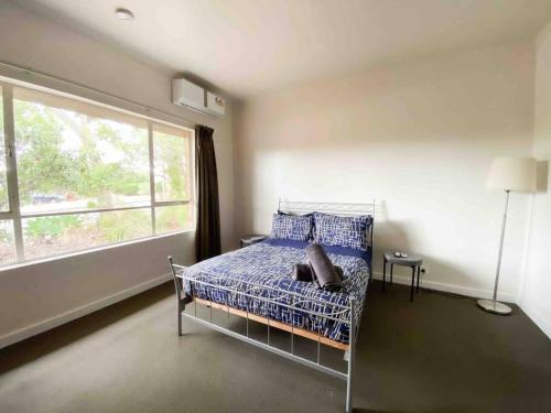 a bedroom with a bed and a large window at large Group house in Windy Corner