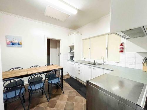 a kitchen with white cabinets and a table and chairs at large Group house in Windy Corner