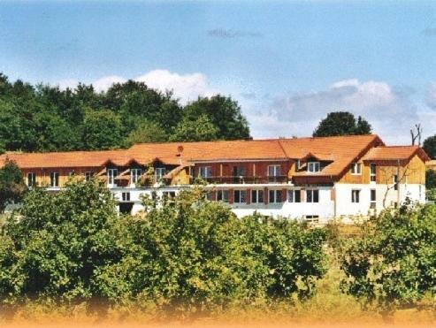 een groot wit gebouw met een rood dak bij Hotel Leo's Ruh in Waldböckelheim