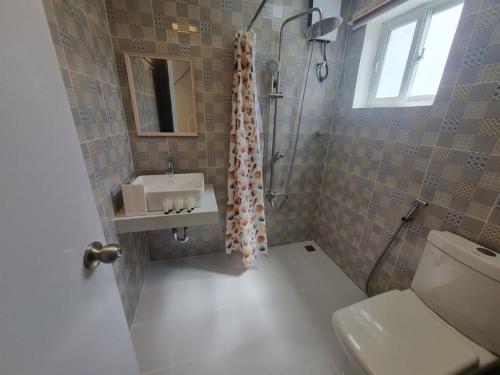 a bathroom with a sink and a shower and a toilet at Villa Excellance Beach and Wave Pool Resort in Postema