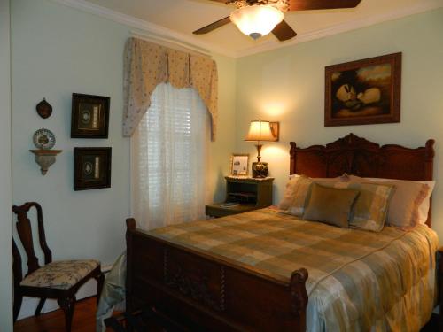 a bedroom with a bed and a chair and a window at EJ Bowman House Bed & Breakfast in Lancaster