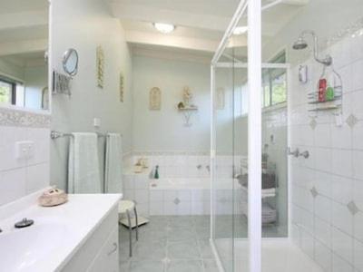 a white bathroom with a shower and a sink at Family Beach Home Dromana in Dromana