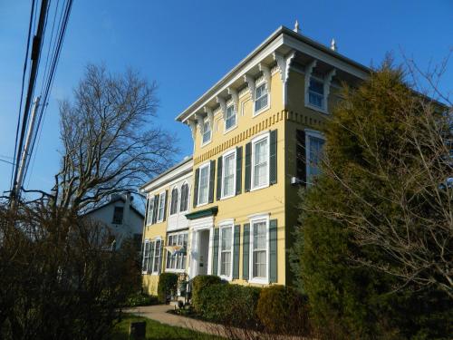 a yellow house with white windows on a street at EJ Bowman House Bed & Breakfast in Lancaster