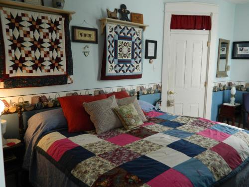 a bedroom with a bed with a colorful quilt on it at EJ Bowman House Bed & Breakfast in Lancaster