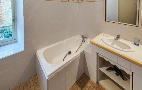 a white bathroom with a tub and a sink at Nice Home In Berlou With Wifi, Private Swimming Pool And 3 Bedrooms in Berlou