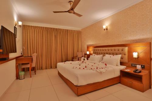 a hotel room with a bed with flowers on it at Lagoona Beach Resort, Kovalam in Kovalam