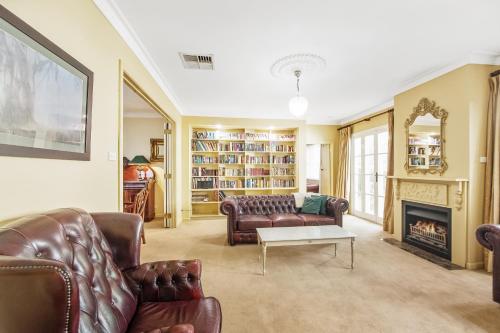 a living room with a couch and a fireplace at Ayr House - Echuca Holiday Homes in Echuca