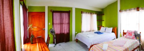 a room with two beds and green walls at Hotel Restaurante Los Cocos in Santa Cruz