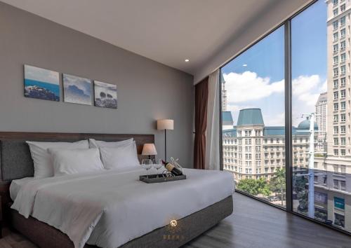 a bedroom with a large bed and a large window at Reyna Hotel Hanoi & Spa in Hanoi