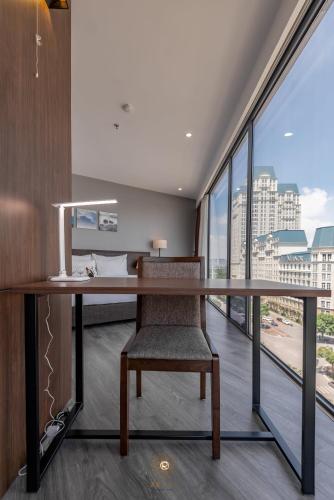 an office with a desk with a chair and large windows at Reyna Hotel Hanoi & Spa in Hanoi